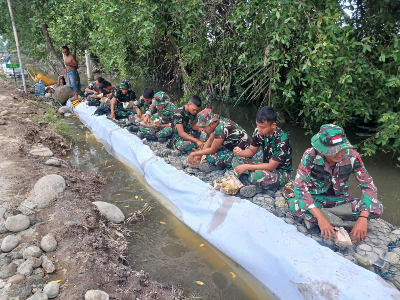 Manfaat Waktu, Prajurit TNI Makan Bersama-sama Di Lokasi Pembangunan Bronjong